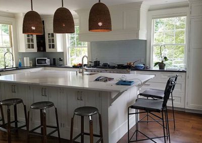 a kitchen with newly painted white cabinets