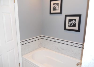 Bathtub and two pictures hanging on the wall