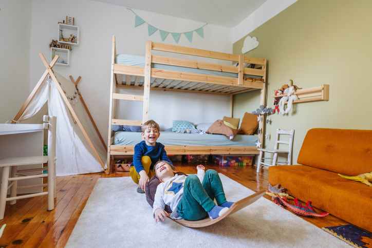 Photo of two little boys playing with balance board in his room